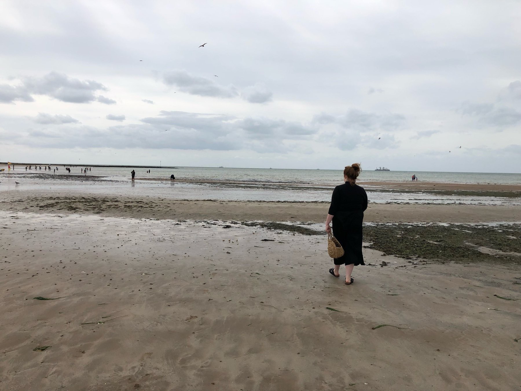 Anna walking towards the water in Margate while tide is low.